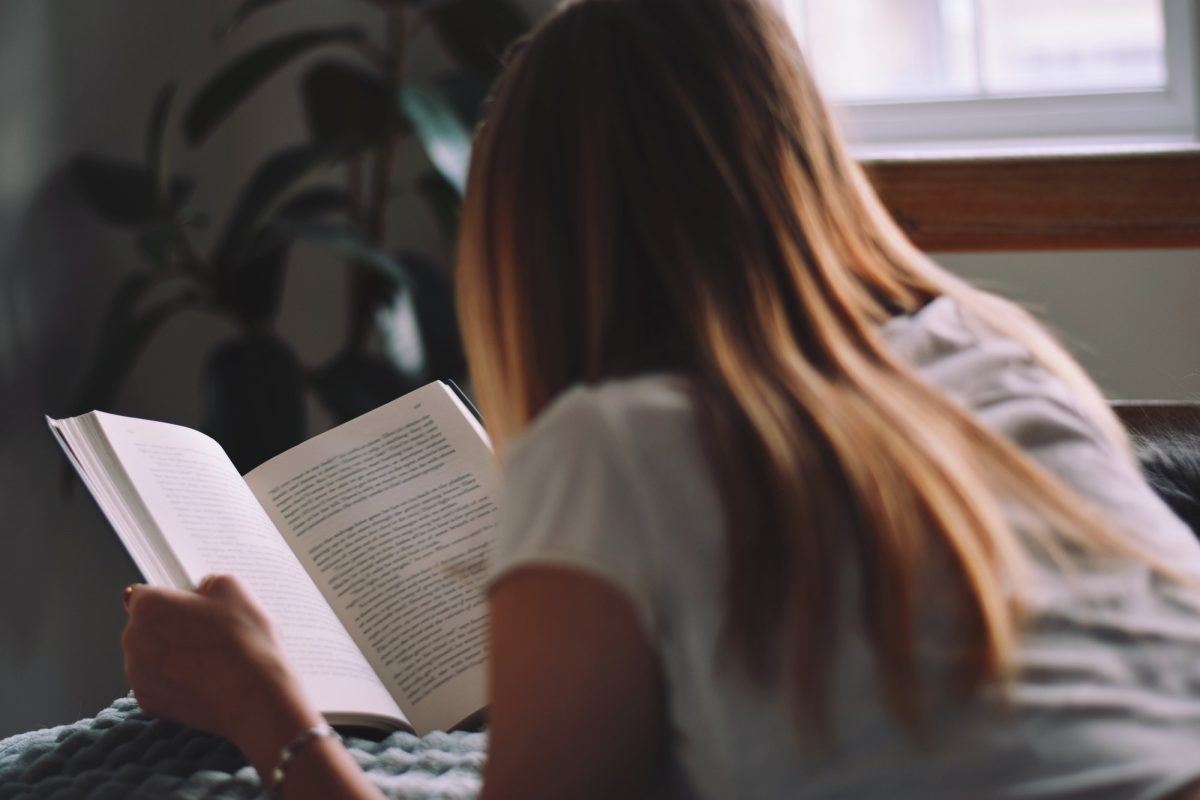 young-teenage-girl-laying-on-her-bed-reading-a-book.jpg